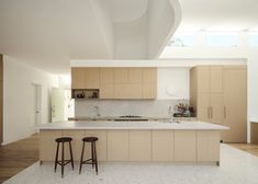 an empty kitchen with two stools in front of the counter and cabinets on both sides