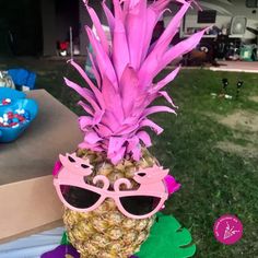 a pineapple with sunglasses on it sitting in the grass