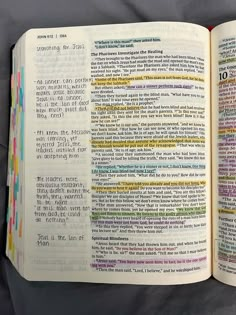 an open bible book with colorful text on the page and in it's center