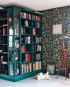 a green bookcase in the corner of a room