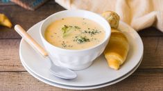 a white bowl filled with soup on top of a plate