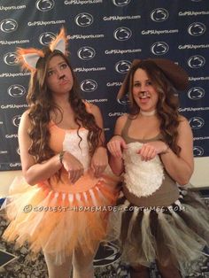 two girls dressed up in costumes standing next to each other on a carpeted floor