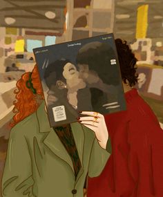 a woman holding up a magazine with an image of a man and woman kissing each other