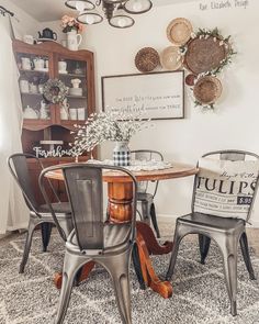 the dining room table is set with two chairs, and there are baskets on the wall above it