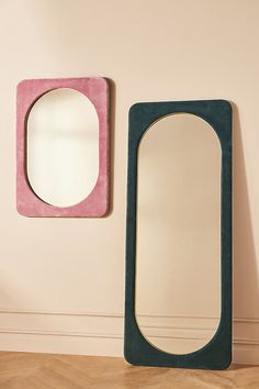 two mirrors are next to each other on the wall, one has a pink and green frame