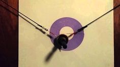 a close up of a clock on a wall with wires attached to the back of it