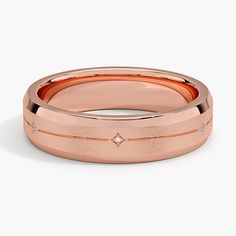 a rose gold wedding band with diamonds on the inside and outside, set against a white background