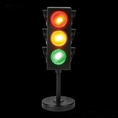 a traffic light that is red, green and yellow in color on a black background