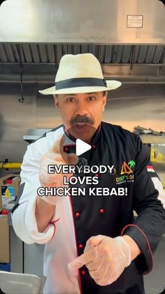 a man in a chef's uniform pointing to the camera with words on it