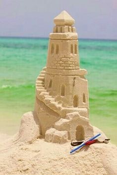 a sand castle on the beach with water in the background