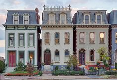 several multi - colored houses line the street in front of each other