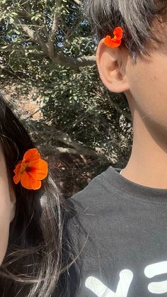 two children with orange flowers in their hair