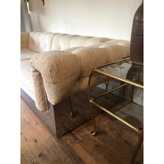 a white couch sitting on top of a wooden floor next to a glass coffee table