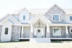 a large gray house with white trim on the front door and steps leading up to it