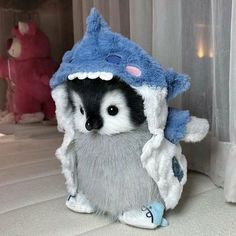 a stuffed animal that is wearing a blue and white house on it's head