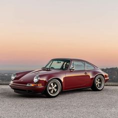 a red porsche parked on top of a parking lot