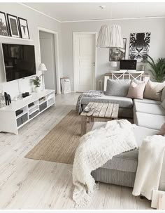 a living room filled with furniture and a flat screen tv on top of a wooden table