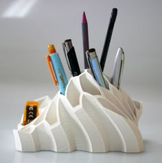 a pen holder with pens and pencils in it