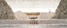 there is a man standing in the middle of an area with large rocks and poles