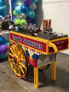 an old fashioned popcorn cart with balloons in the background