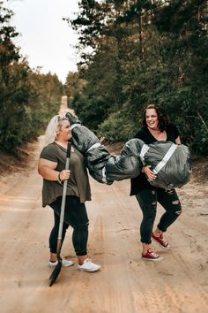 two women walking down a dirt road with bags on their backs and one carrying a large bag