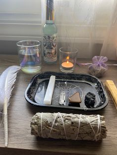 an assortment of items on a tray next to a candle