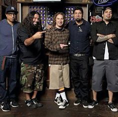 five men standing together in front of a bar