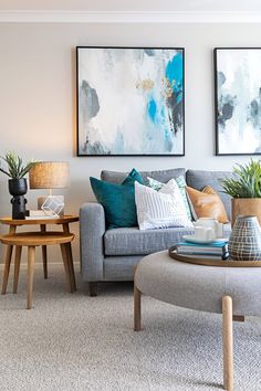 a living room filled with furniture and paintings on the wall above it's coffee table