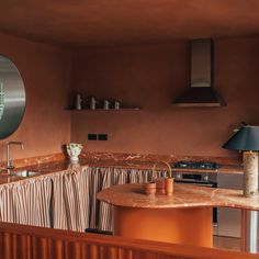 a kitchen with orange walls and marble counter tops