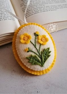 a book is open on the table next to an ornament with yellow flowers