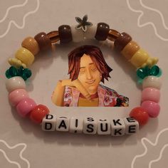 a beaded bracelet with an image of a woman on it and words that read daisuke