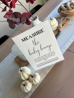 a sign that says measure the baby bumps on a table with some pumpkins