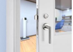 an open door with the handle on it in front of a kitchen and living room