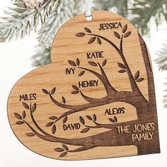 a wooden ornament hanging from a tree with names on it's heart