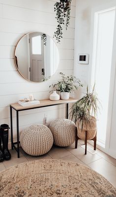 a living room with a rug, mirror and plant on the wall next to it