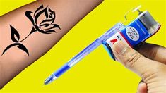 a person with a tattoo on their arm is holding a pen and an ink roller