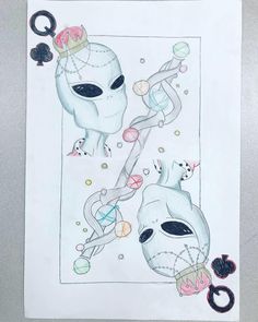 a drawing of two alien heads on top of a piece of paper with scissors in it