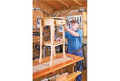 a man is working on a piece of furniture in his shop with woodworking tools