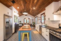 a kitchen with an island, stove and refrigerator freezer next to a counter top