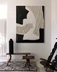 a painting hanging on the wall next to a wooden bench and table in a living room