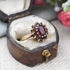 A lovely Mid-Century vintage 9ct gold and garnet floral cluster ring. A wonderful, quality piece of vintage fine jewellery. Stamped with UK hallmarks for 9ct gold to the inside, 1974. In really nice vintage condition. Please be sure to see all of the photos. - UK Size - K - US Size - 5 1/4 - Weight - 2.5 grams -------------------- All boxes and stands in the photographs are for display purposes only, unless otherwise stated. Please be aware there will be marks and wear commensurate with age. Ple Garnet Rings Vintage, Garnet Vintage Ring, Vintage Garnet Ring, Antique Rings Victorian, Garnet Ring Vintage, Floral Halo, Vintage Fine Jewelry, Dream Engagement Rings, Red Gemstones