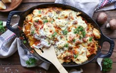 a casserole dish with meat and cheese in a cast iron pan on a wooden table