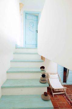 there is a blue door and some steps in the house that have been painted white