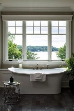 a large white bath tub sitting next to a window