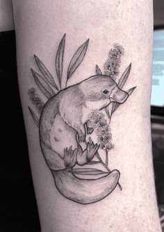 an animal with flowers on its leg is shown in black and white tattoo art style