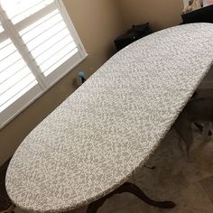 an ironing board sitting on top of a table in a room with white shutters