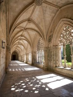 the sun is shining in an old building with stone arches and windows on both sides