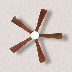 an overhead view of a ceiling fan with four wooden blades and a white disc in the center