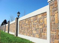 a stone wall next to a street light