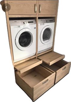 an open washer and dryer in a wooden cabinet with drawers on each side